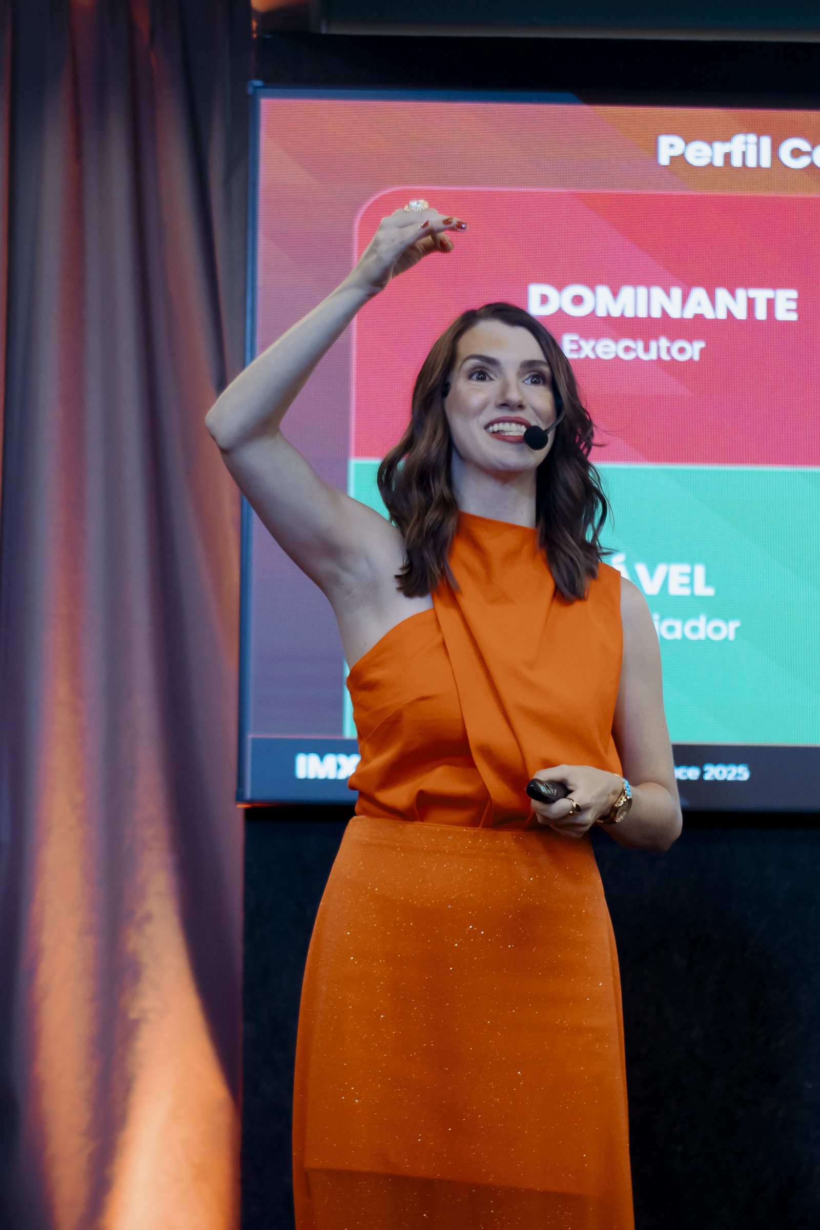 Palestrante em apresentação no palco do IMX25